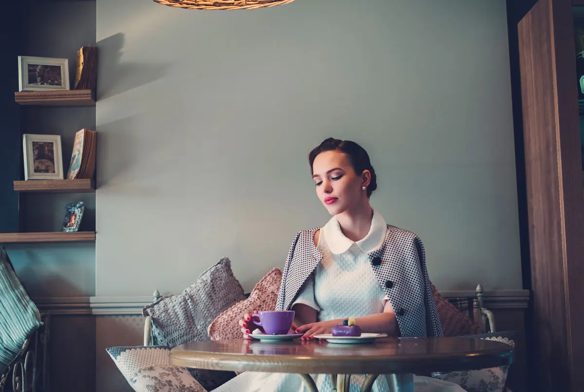 Nachdenkliche Frau zeigt kein Interesse, sitzt allein in einem Café und trinkt Kaffee.