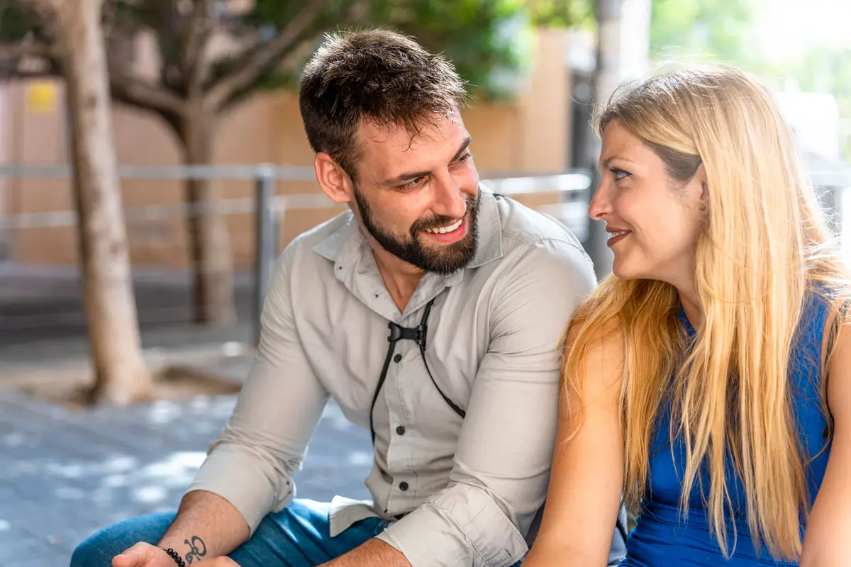 Ein verliebter Mann lächelt einer Frau zu, während sie sich liebevoll in die Augen schauen – ein Zeichen von Zuneigung und emotionaler Verbindung.
