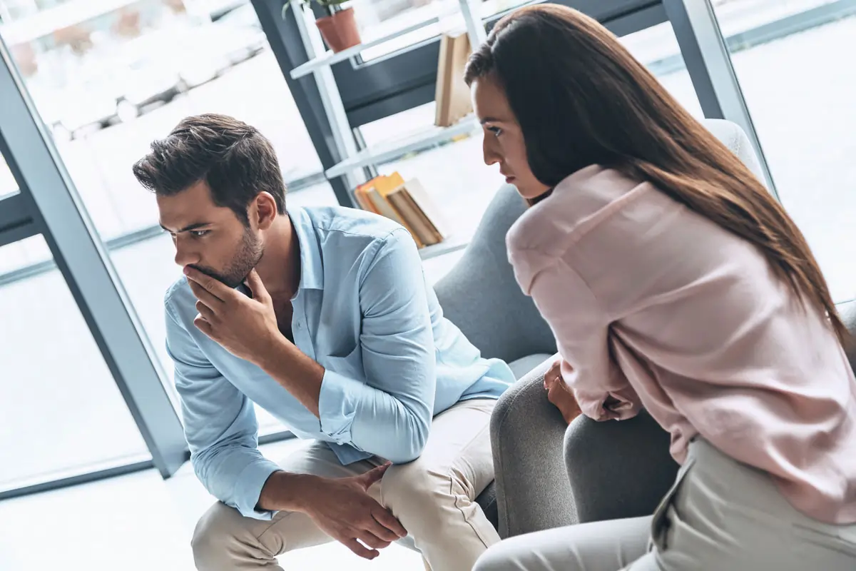 Nachdenkliches Paar nach einer Affäre, das ernsthaft über die Zukunft ihrer Beziehung nachdenkt – Symbol für die Unsicherheiten und emotionalen Herausforderungen nach einem Vertrauensbruch in der Ehe.