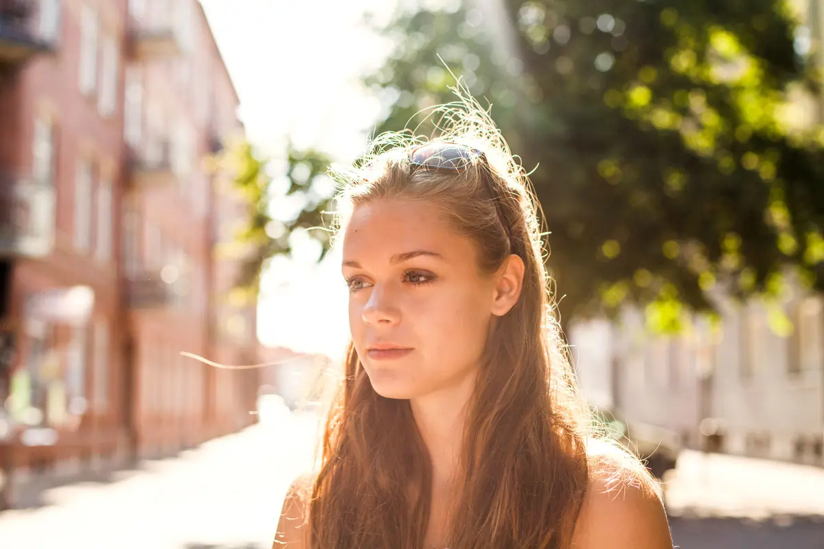 Eine nachdenkliche junge Frau blickt in die Ferne, symbolisiert die emotionale Belastung und das Nachdenken darüber, was mit der Psyche passiert, wenn man betrogen wird.